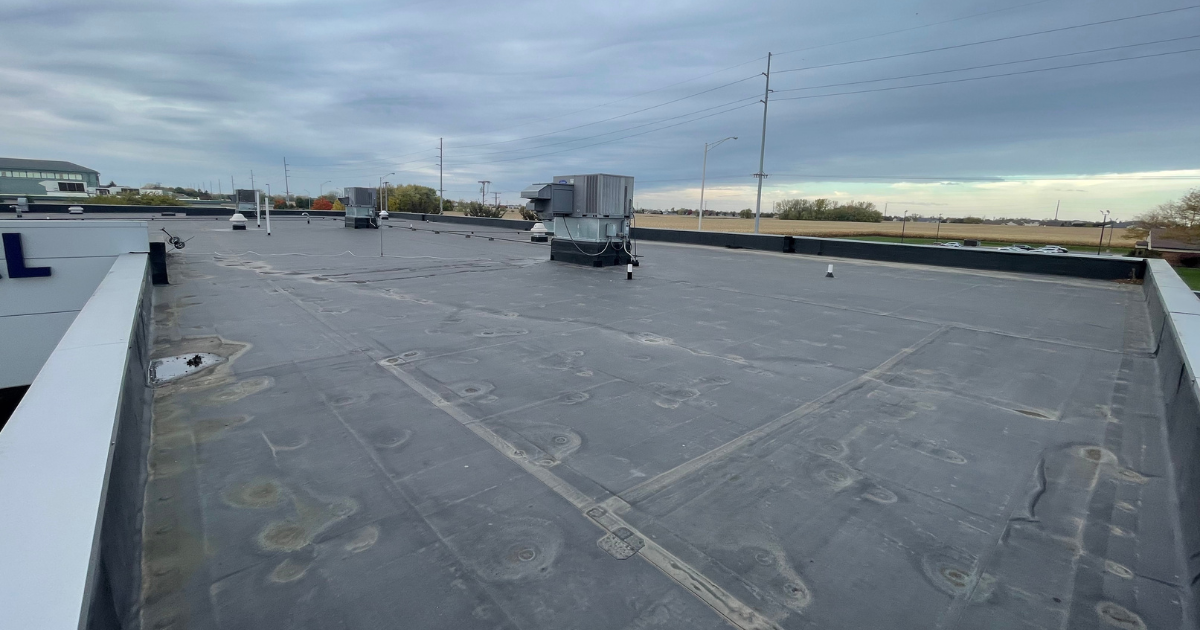 Aged commercial flat roof showing wear and signs of deterioration