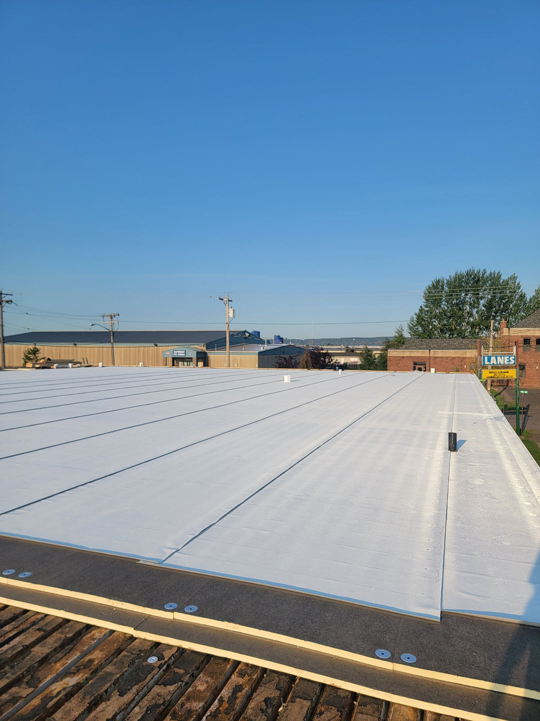 White TPO flat roof installation with edge detail — commercial roofing replacement by Pristine Industrial Roofing
