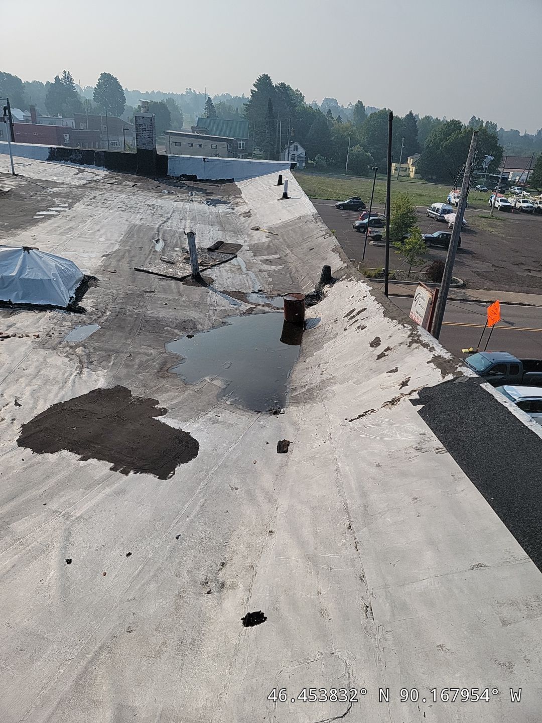 Roof mid-repair showing patched sections and flagged penetrations