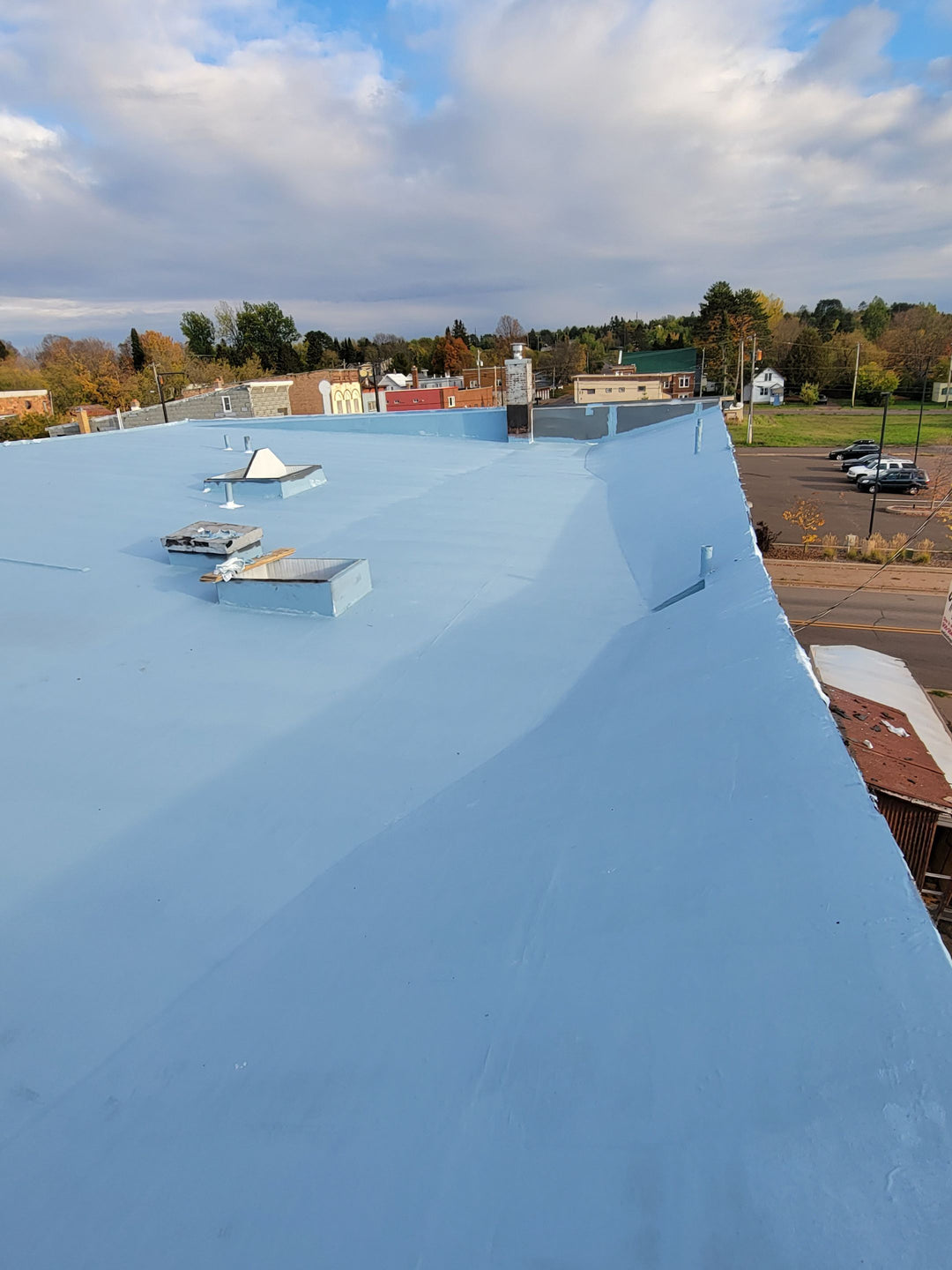 Blue coating applied over commercial flat roof