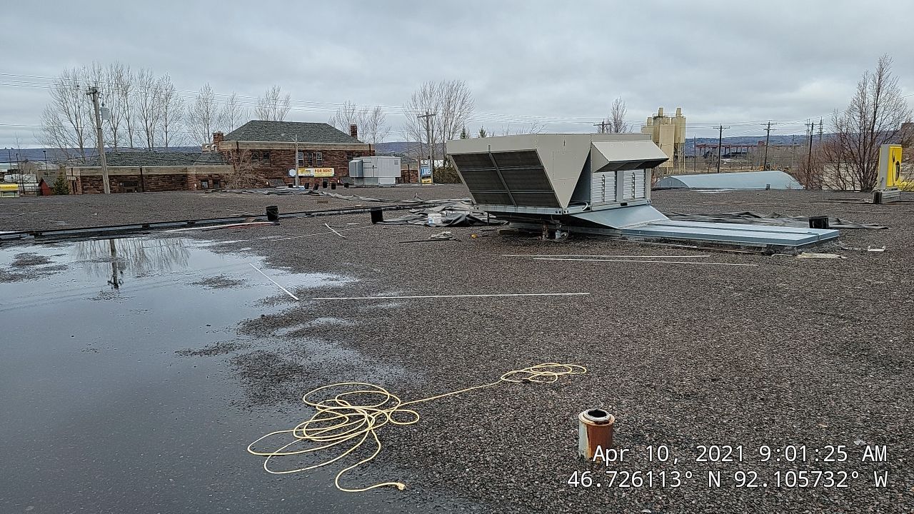 Flat roof with ponding water and storm-damaged HVAC unit