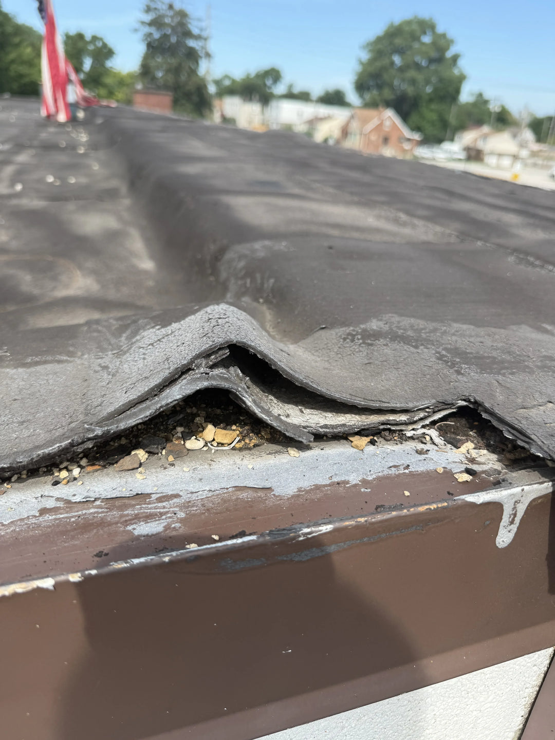 Damaged roof with missing shingles and exposed gutters.