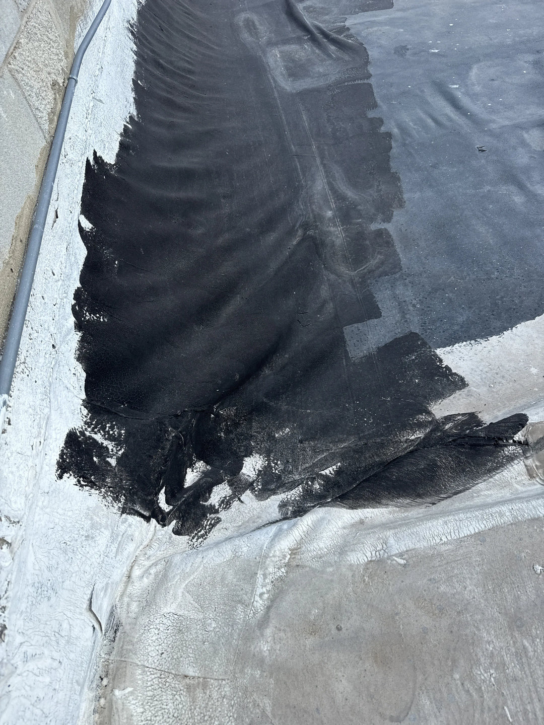 Large black tire tread on a concrete surface