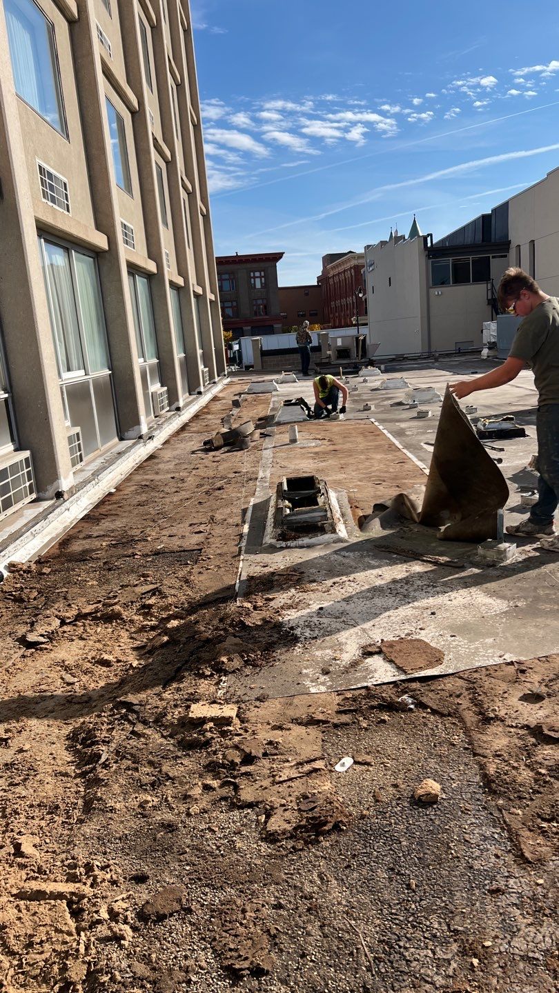 Pristine Industrial Roofing crew performing commercial flat roof tear-off and restoration on multi-story building — Northwest Indiana